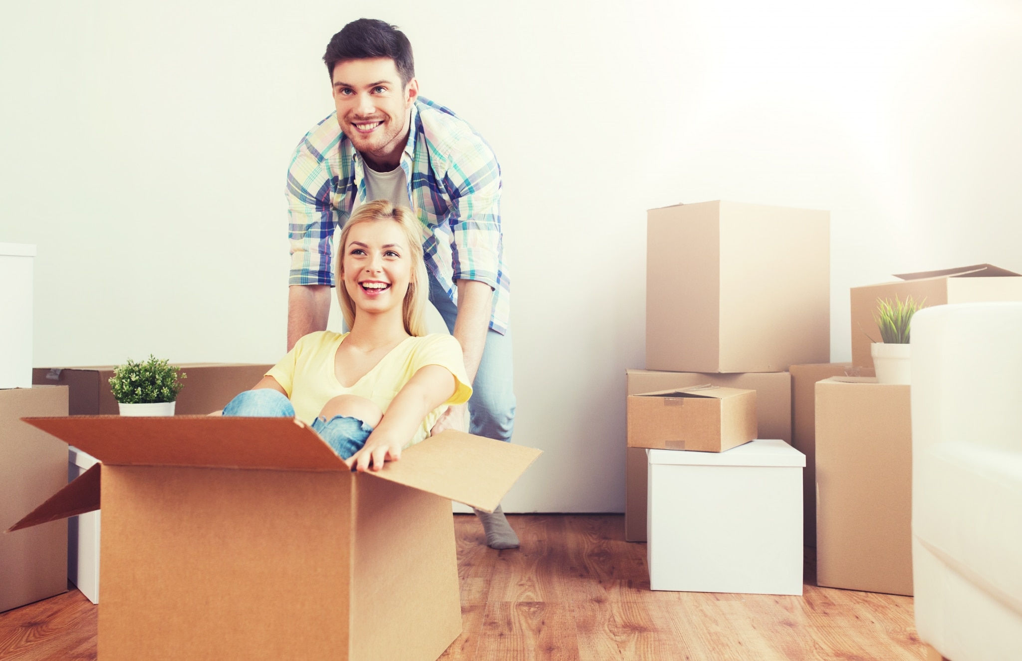 Happy Couple Having Fun With Boxes At New Home